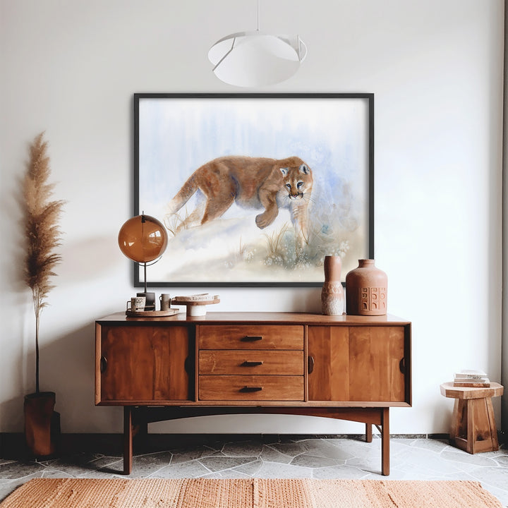Edge Walker mountain lion watercolor in a dark wood frame, displayed in a modern interior
